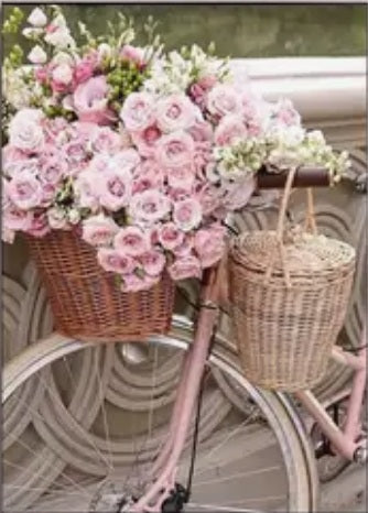 Pink bicycle with flowers in basket